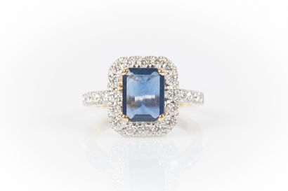 Two-tone gold ring set with an emerald-cut...