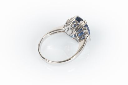 White gold ring set with an oval-cut sapphire...
