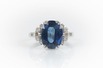 White gold ring set with an oval-cut sapphire...
