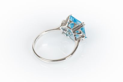 White gold ring set with an emerald-cut topaz...
