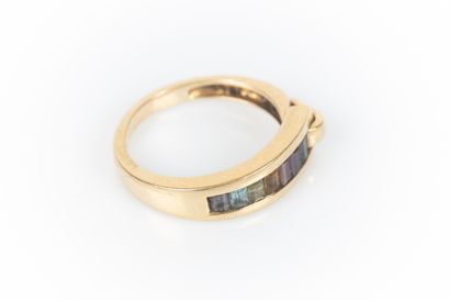 Gold ring set with calibrated gemstones in...