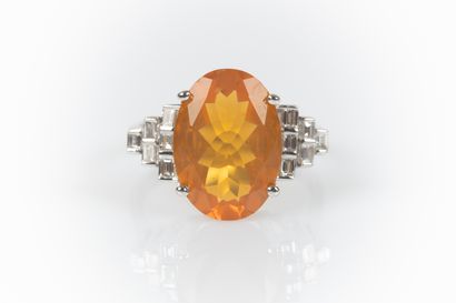 White gold ring set with a fire opal weighing...