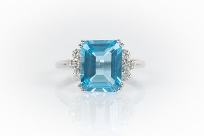 White gold ring set with an emerald-cut topaz...