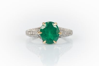 Two-tone gold ring set with an oval emerald...