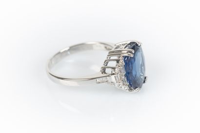 White gold ring set with an oval-cut sapphire...