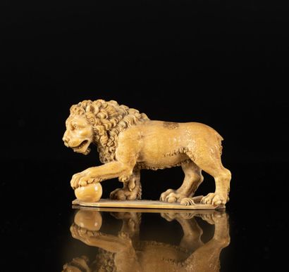 Lion en ivoire sculpté en ronde-bosse. La...