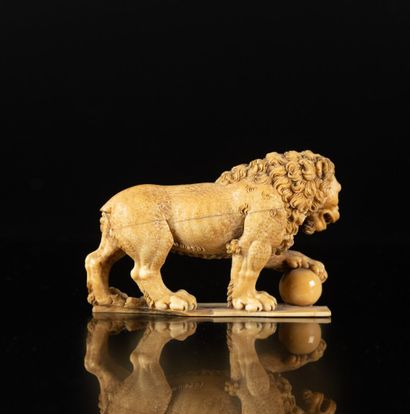 Lion en ivoire sculpté en ronde-bosse. La...