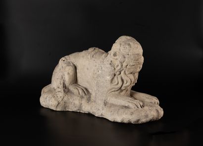 Lion en calcaire sculpté. Allongé, la queue...