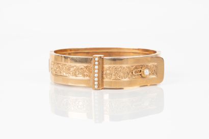 Bracelet rigide ouvrant en or gravé de rinceaux...