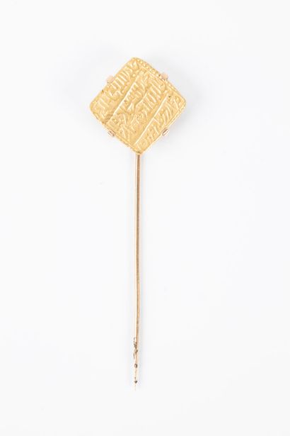 Gold tie pin set with a rectangular coin...