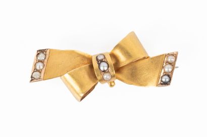 Broche noeud en or sertie de petites perles...
