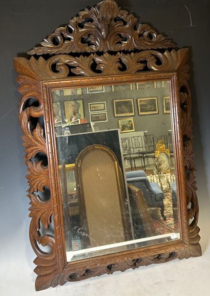 Wooden mirror decorated with openwork scrolls....