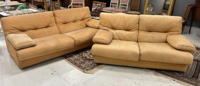 Two beige-turned-leather sofas, one with...