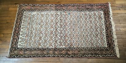 Tapis d'Orient à fond beige et bordure saumon....