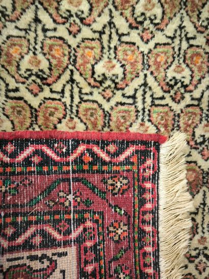 Tapis d'Orient à fond beige et bordure saumon....