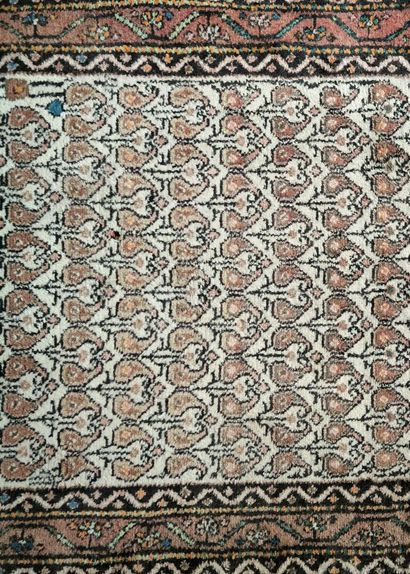 Tapis d'Orient à fond beige et bordure saumon....