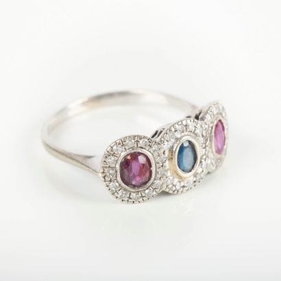 White gold ring set with a sapphire surrounded...