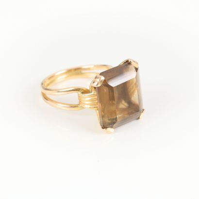 Gold ring set with an emerald-cut smoky quartz....