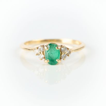 Gold ring set with an oval emerald weighing...