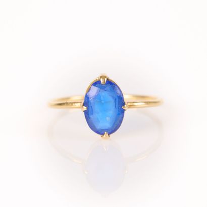 Gold ring (750‰) set with an oval blue stone....