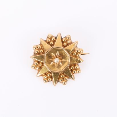 Gold star brooch set with a cultured pearl....