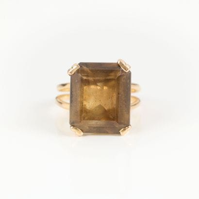 Gold ring set with an emerald-cut smoky quartz....