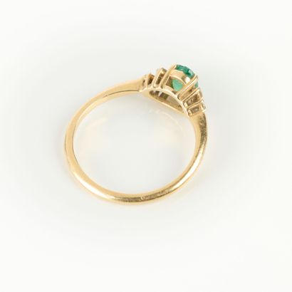 Gold ring set with an oval emerald weighing...