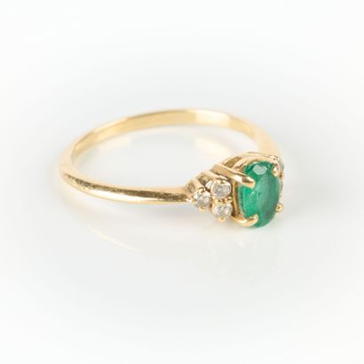 Gold ring set with an oval emerald weighing...