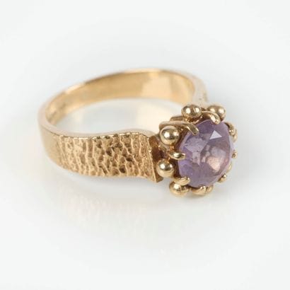 Small gold ring set with a round amethyst,...