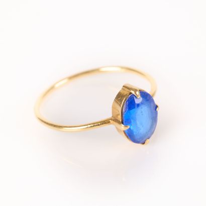 Gold ring (750‰) set with an oval blue stone....