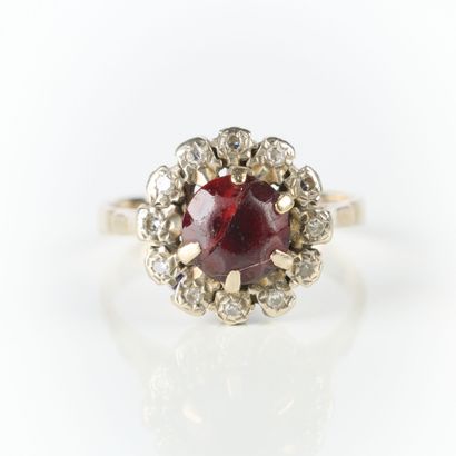 White gold ring set with a red stone in a...