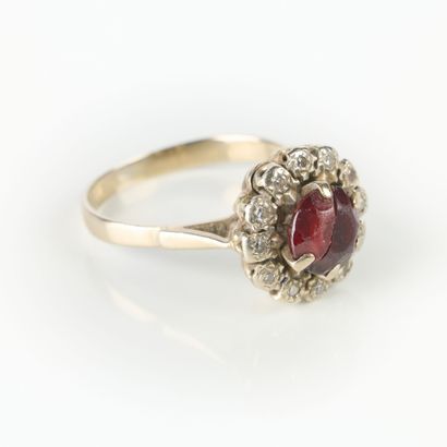 White gold ring set with a red stone in a...