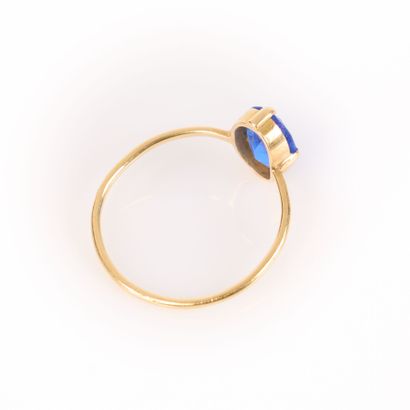 Gold ring (750‰) set with an oval blue stone....