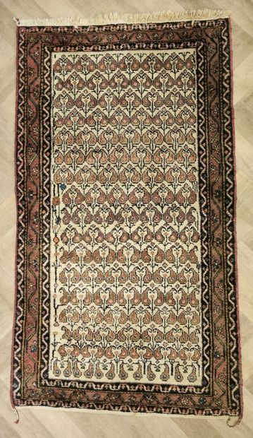 Tapis d'Orient à fond beige et bordure saumon....