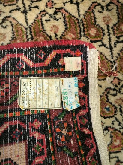 Tapis d'Orient à fond beige et bordure saumon....