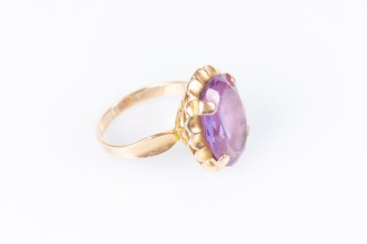 Gold ring (750‰), set with an oval pink stone....