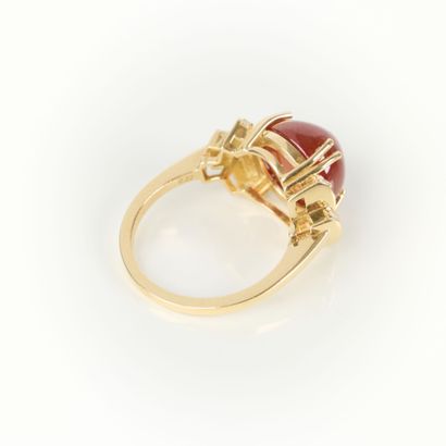 Gold ring (750‰) set with a round cabochon...