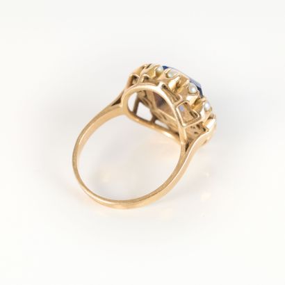 Gold ring set with a blue stone surrounded...
