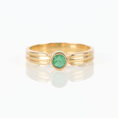 Gold solitaire ring set with a round emerald....