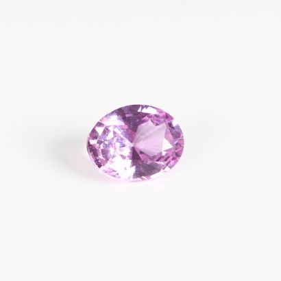 Oval-cut pink sapphire on paper with certificate...