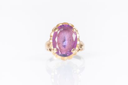 Gold ring (750‰), set with an oval pink stone....
