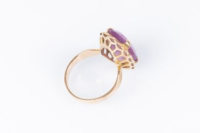 Gold ring (750‰), set with an oval pink stone....