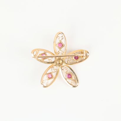 Gold flower brooch set with small rubies...