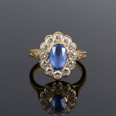 Gold ring set with an oval sapphire weighing...