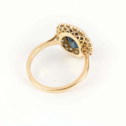 Gold ring set with an oval sapphire weighing...