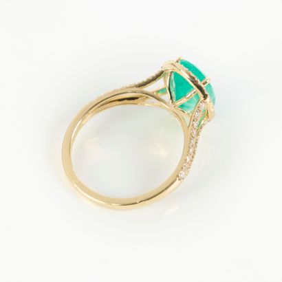 Gold ring (750‰), set with an oval-cut Colombian...