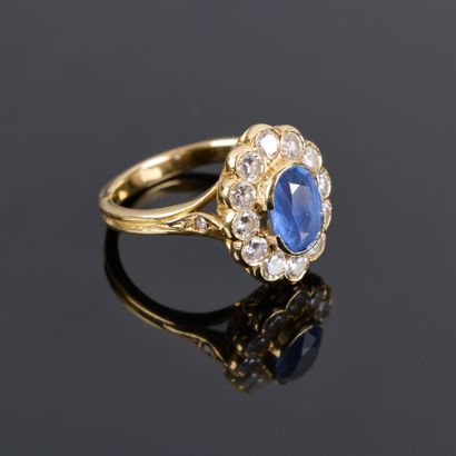 Gold ring set with an oval sapphire weighing...