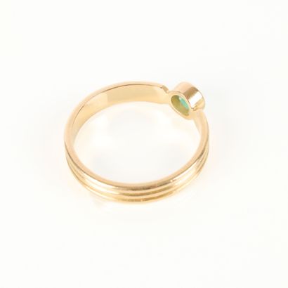 Gold solitaire ring set with a round emerald....