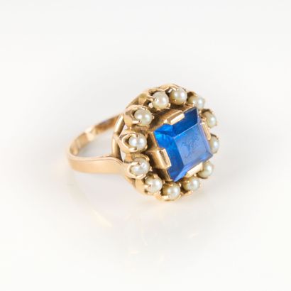 Gold ring set with a blue stone surrounded...