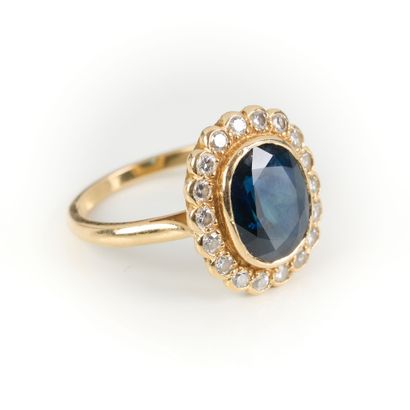 Gold ring set with an oval sapphire weighing...